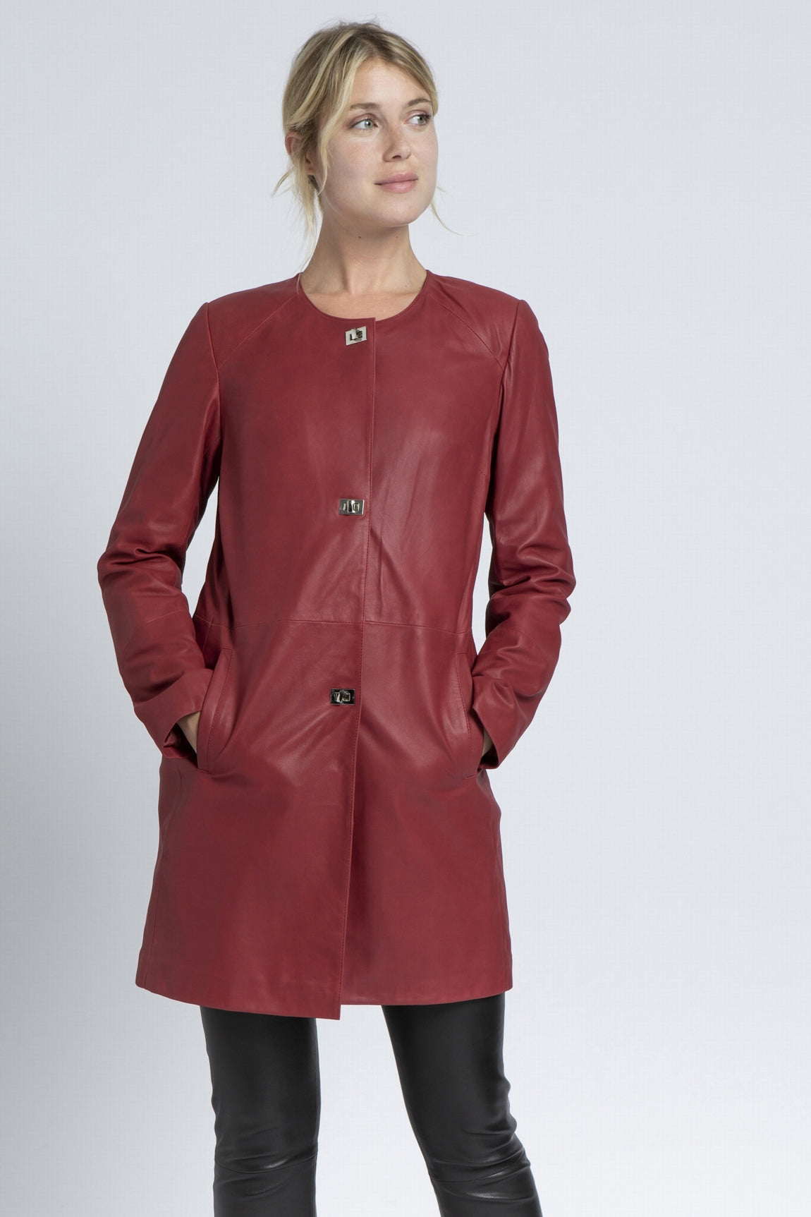 Vue portée d'un manteau en cuir rouge 3/4 de Giorgio & Mario, avec des attaches métalliques carrées, style sophistiqué. 